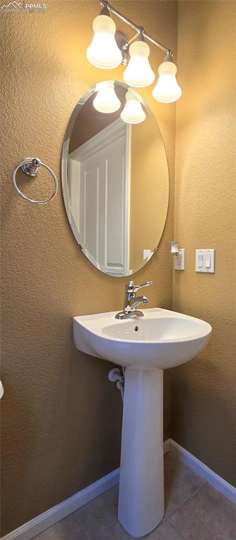 Bathroom featuring a textured wall and tile patterned floors