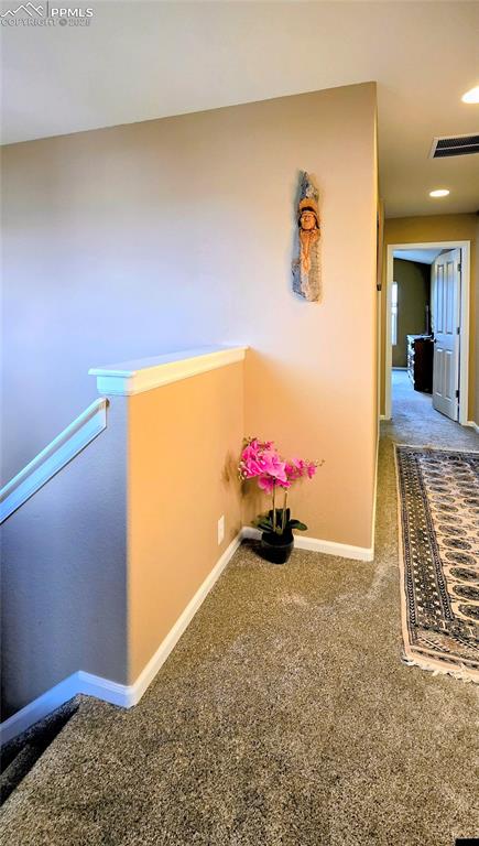 Hall with carpet flooring and an upstairs landing