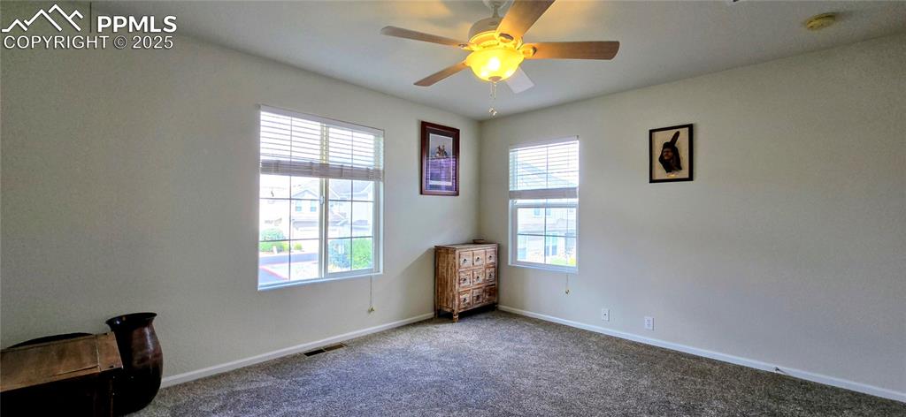 Empty room with carpet and a ceiling fan