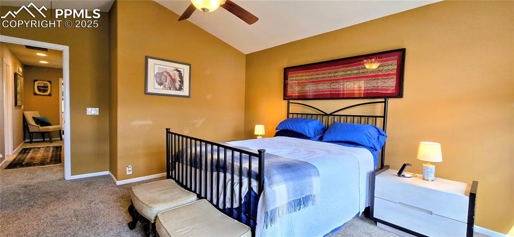 Bedroom featuring carpet floors, lofted ceiling, and a ceiling fan