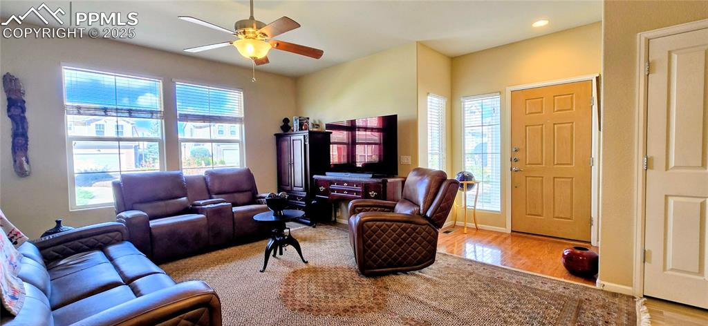Living room featuring light wood-style floors, ceiling fan, and recessed lighting