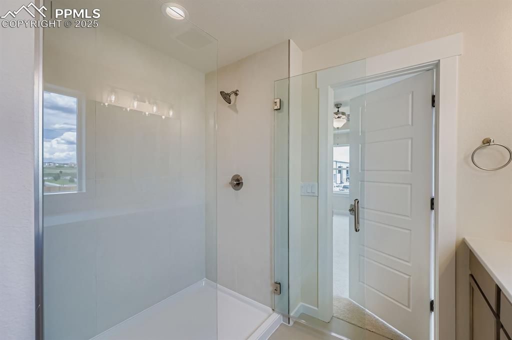 Full bath with a shower stall, vanity, and healthy amount of natural light