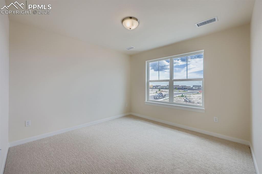 Empty room featuring light colored carpet and a water view