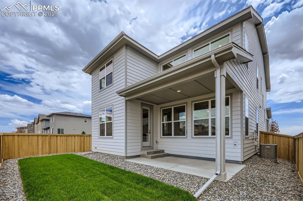 Rear view of house featuring a fenced backyard and a patio area