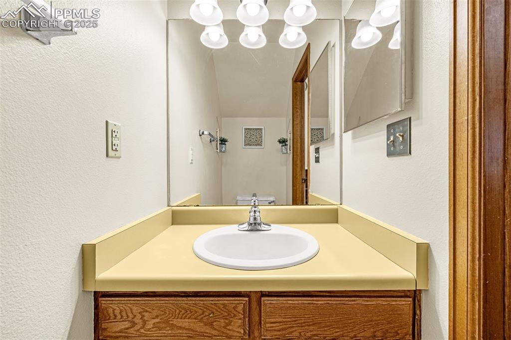 Bathroom with a textured wall and vanity