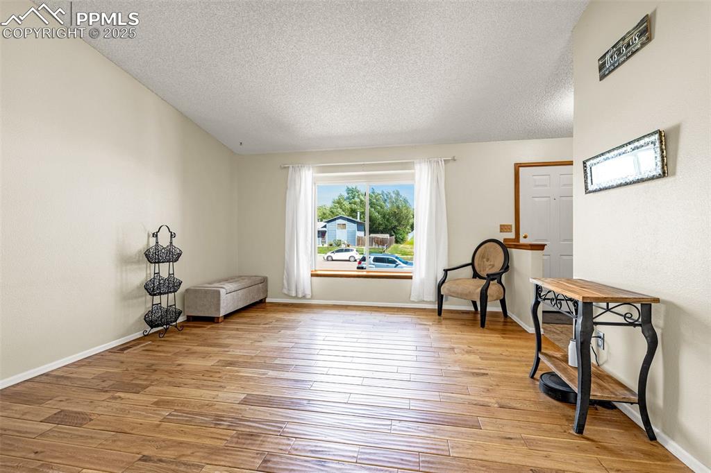 Sitting room featuring a textured ceiling and light wood-type flooring