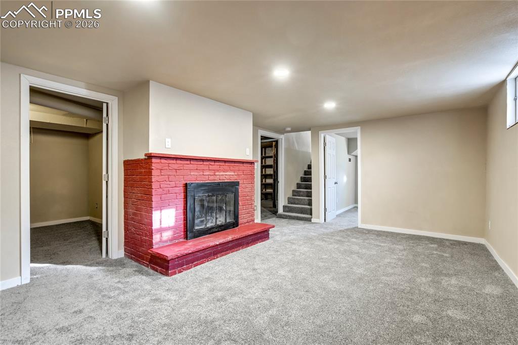 Basement family room with fireplace, and recessed lighting.