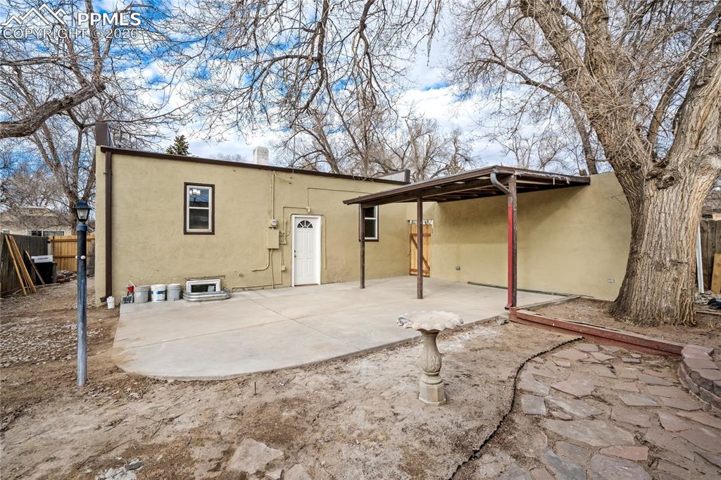 Back of house, featuring mature trees and a birdbath