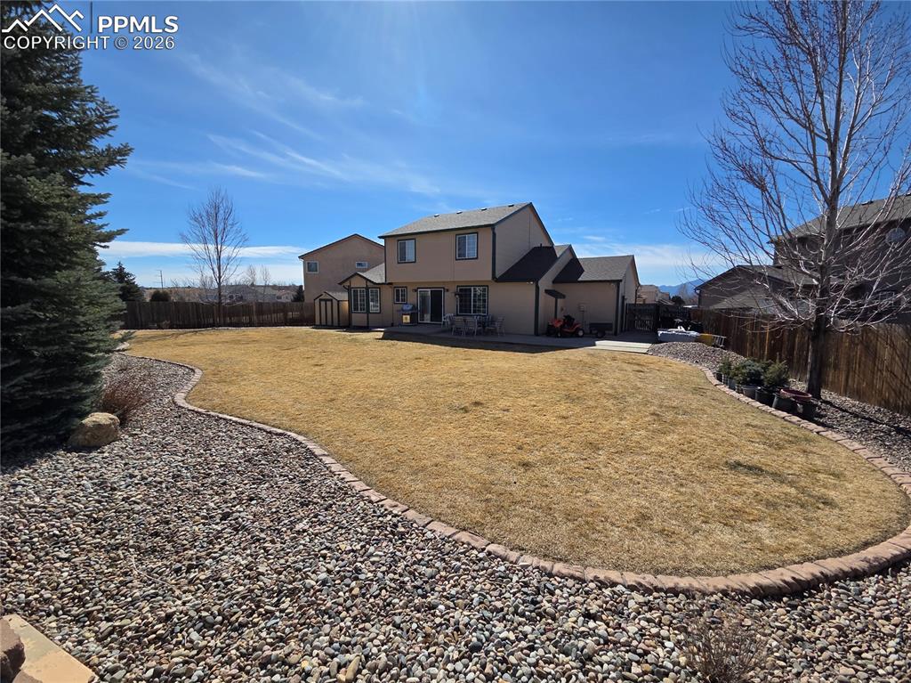 Back of house with a fenced backyard and stucco siding