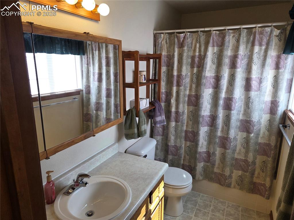 Bathroom featuring vanity, a shower with curtain, and light tile patterned floors