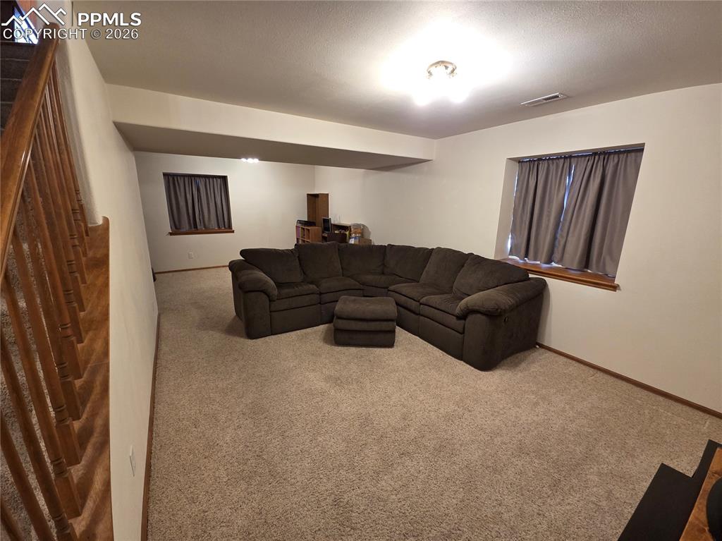 Living room with carpet flooring and stairway