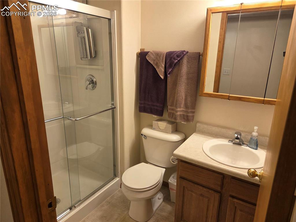 Bathroom with vanity, a stall shower, and light tile patterned flooring