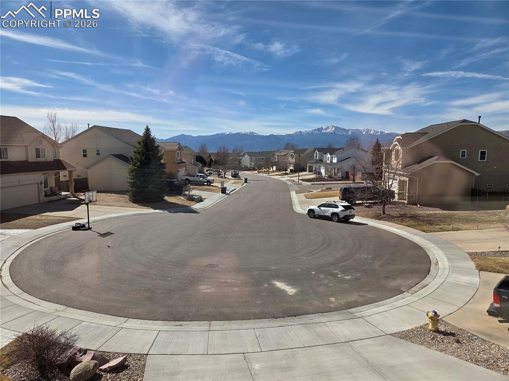 View of road featuring sidewalks, a residential view, curbs, and a mountain view