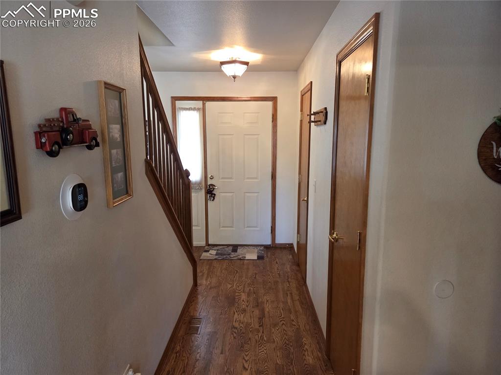 Doorway featuring wood finished floors and stairs