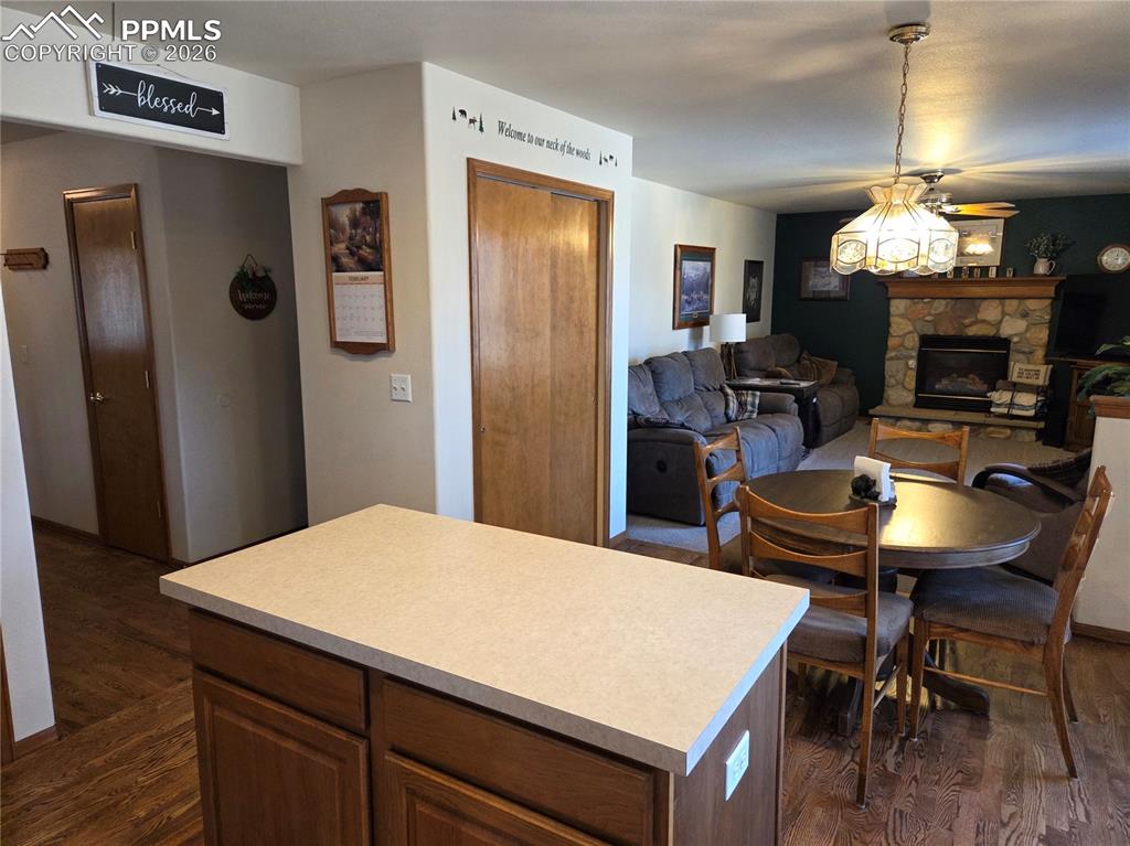 Kitchen featuring light countertops, a kitchen island, and dark wood-type flooring