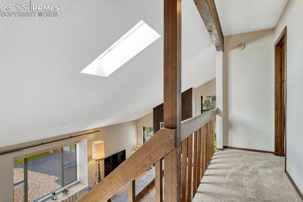 A beautifully designed hallway, plush carpet floors, and a stunning skylight. 
