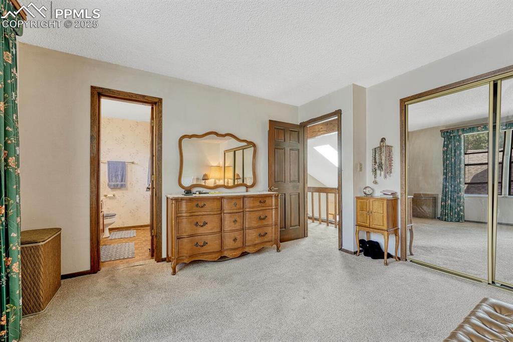 Bedroom featuring a textured ceiling, light colored carpet, and a closet