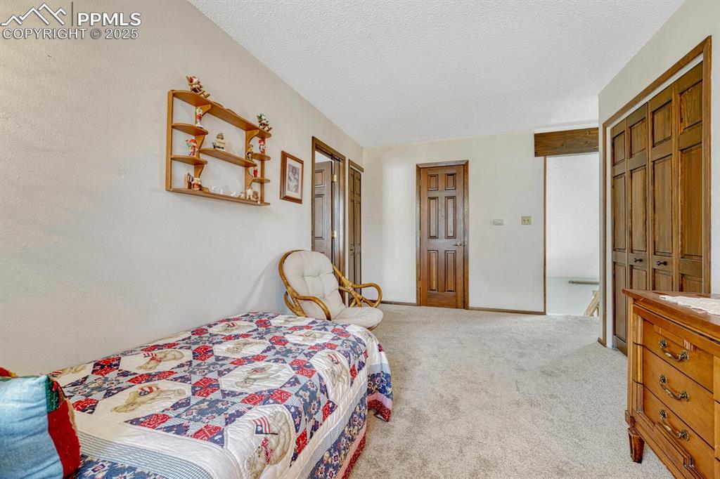 Carpeted bedroom with a textured ceiling and baseboards