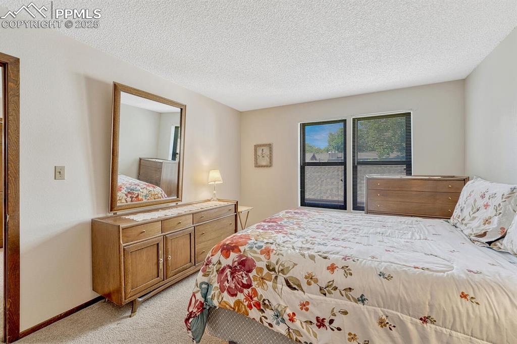 Bedroom featuring light carpet and a textured ceiling