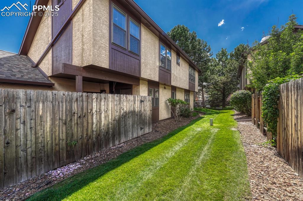View of side of property with stucco siding and a fenced backyard