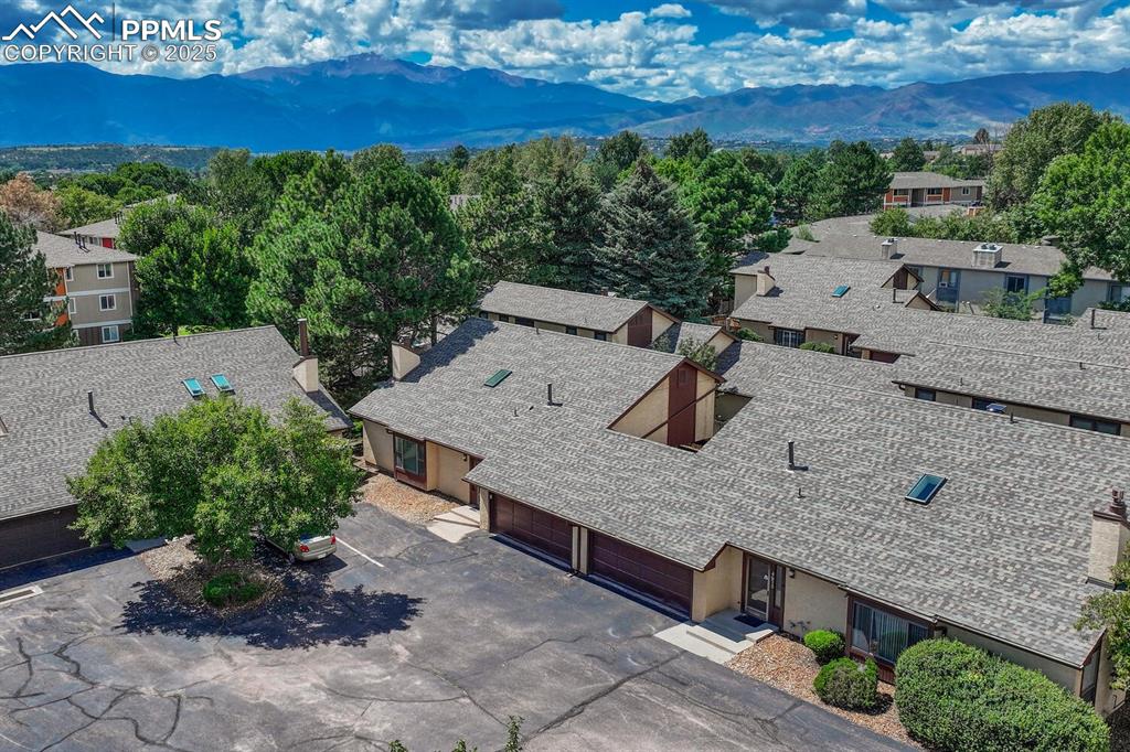 A captivating aerial view showcases this exceptional property, complete with a serene pool area and charming suburban surroundings, breathtaking mountain background 