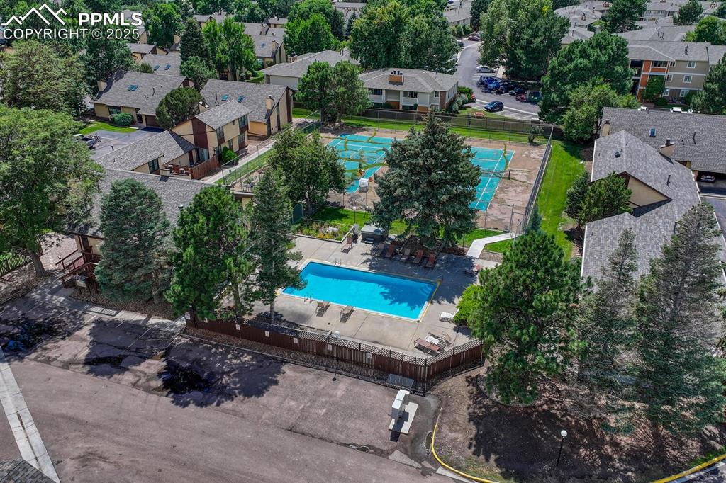 Aerial view of property and surrounding area featuring a pool area and nearby suburban area