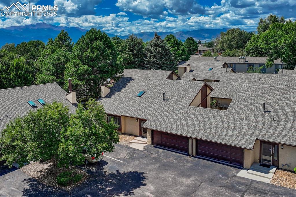 A captivating aerial view showcases this exceptional property, complete with a serene pool area and charming suburban surroundings, breathtaking mountain background