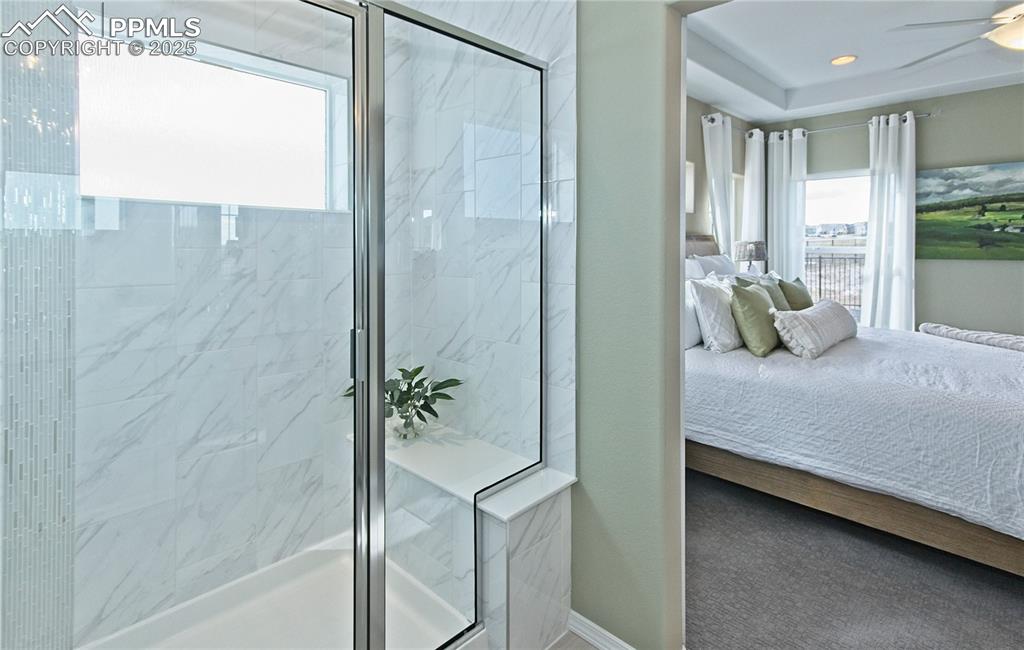 Bathroom featuring ensuite bathroom, plenty of natural light, and a marble finish shower
