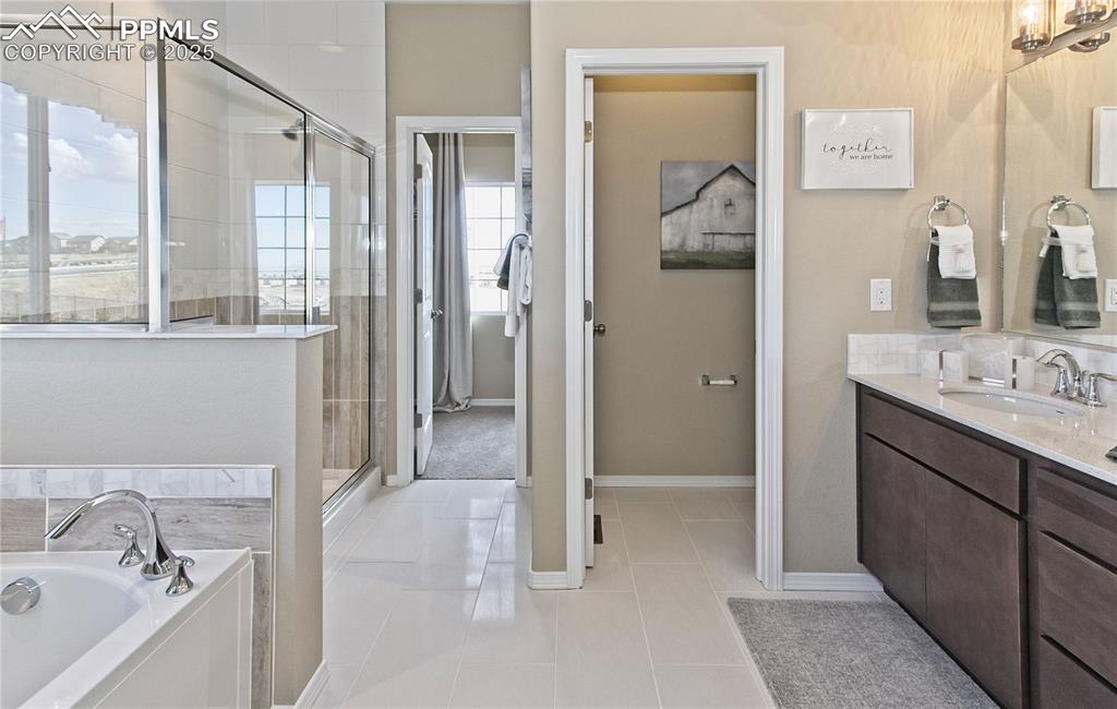 Full bathroom with a shower stall, vanity, a garden tub, and tile patterned flooring
