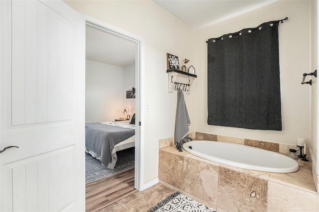 Ensuite bathroom with a garden tub and baseboards