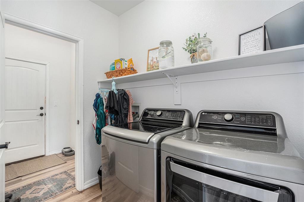 Laundry area featuring light wood-style flooring and washing machine and dryer