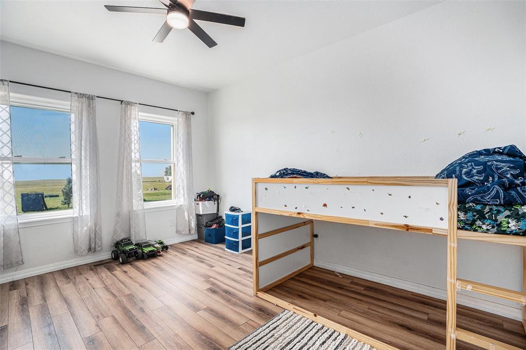 Bedroom featuring wood finished floors and a ceiling fan
