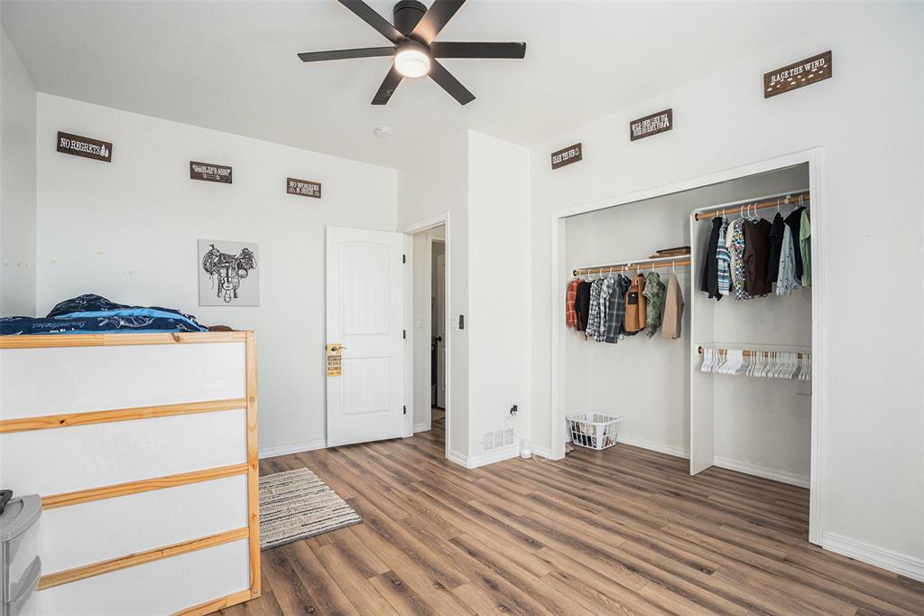 Bedroom featuring wood finished floors, a closet, and a ceiling fan