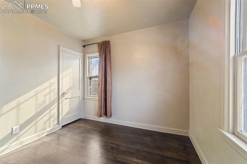 Unfurnished room with dark wood-type flooring and baseboards