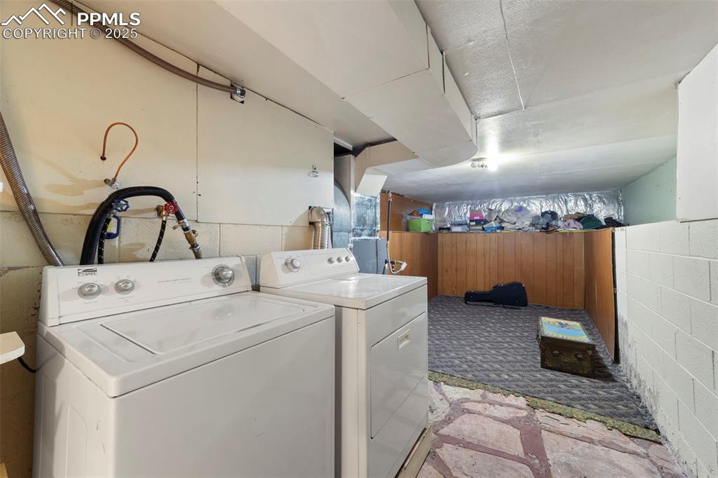 Laundry area featuring washing machine and dryer and wooden walls