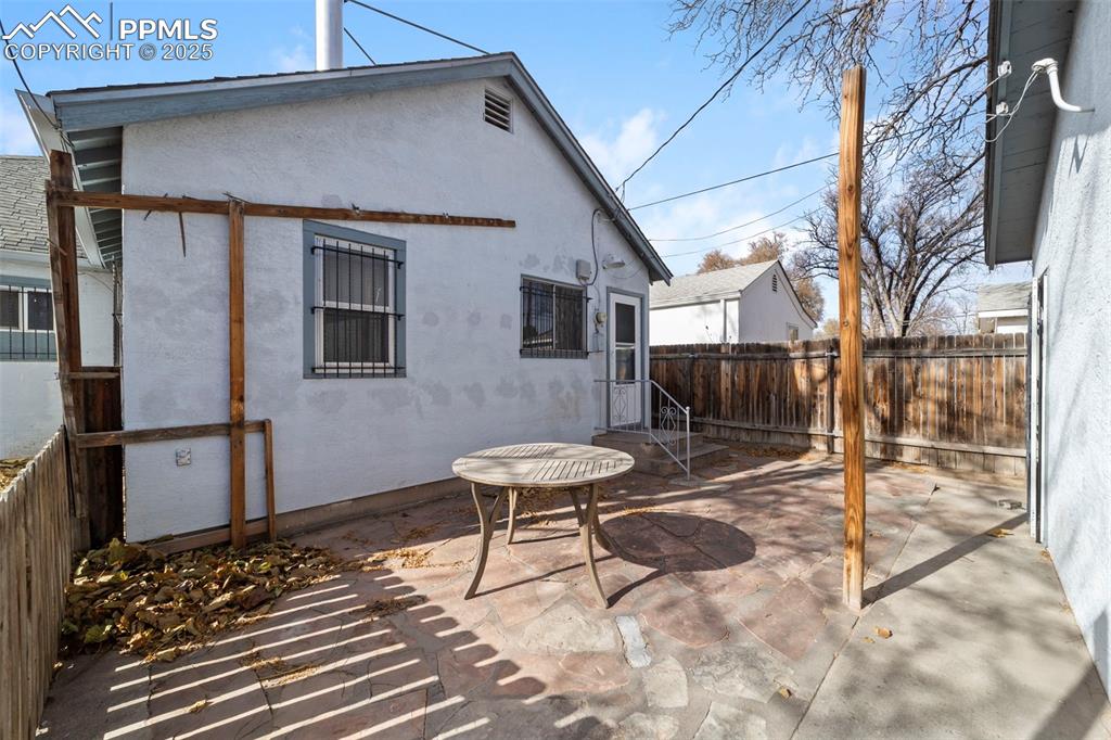 Rear view of property featuring a patio, stucco siding, and a fenced backyard