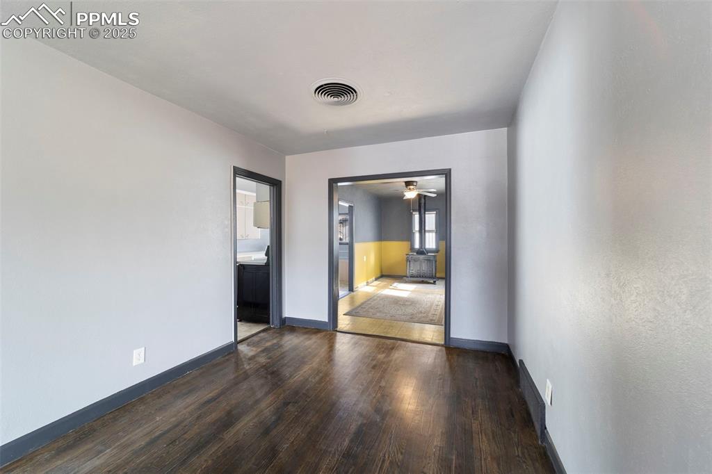Unfurnished room with dark wood-style floors and ceiling fan