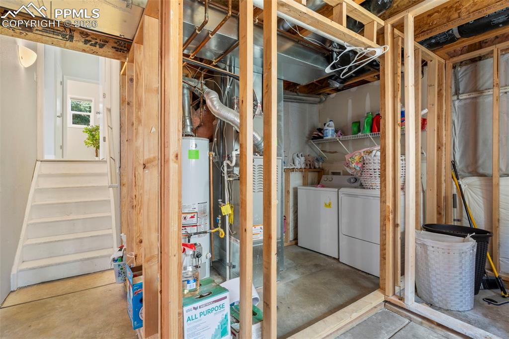Unfinished below grade area featuring washing machine and dryer and water heater