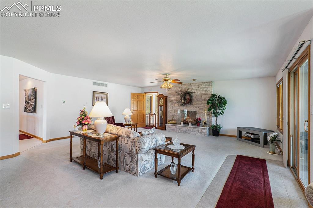 Living room with plenty of natural light and a stone fireplace.