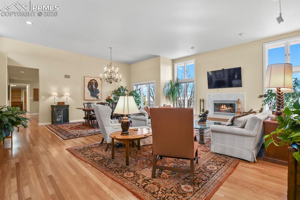 Living Room, open to the Dining Area, with beautiful chandelier. Some canned lighting. Hardwood floors.  Light filled. 