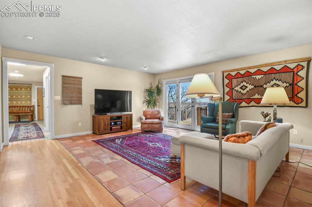 Another view of the family room, showing the french doors to the totally rebuilt deck, with Trex composite materials and wrought iron railings. Enjoy the views.  The doors to the mud room area with the back door entrance to the home and the door to the garage.  
