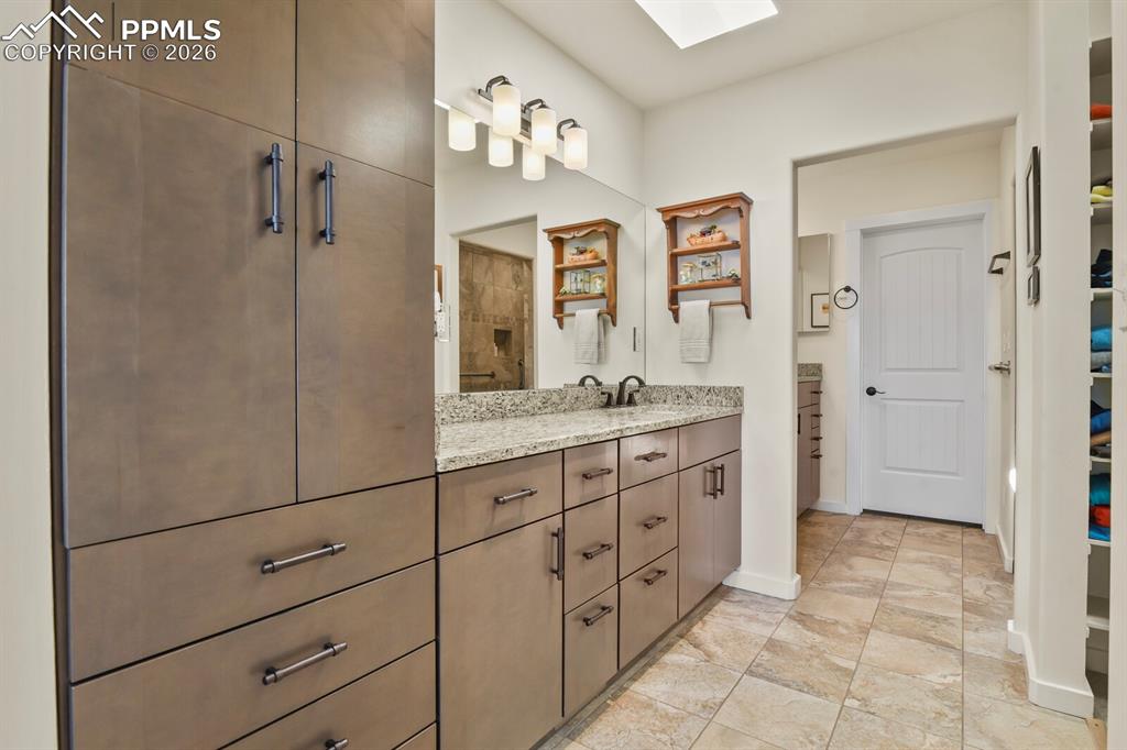 Another view of the Primary Bathroom showing one of the two vanities and all the storage cupboards available. Door into the walk-in closet.