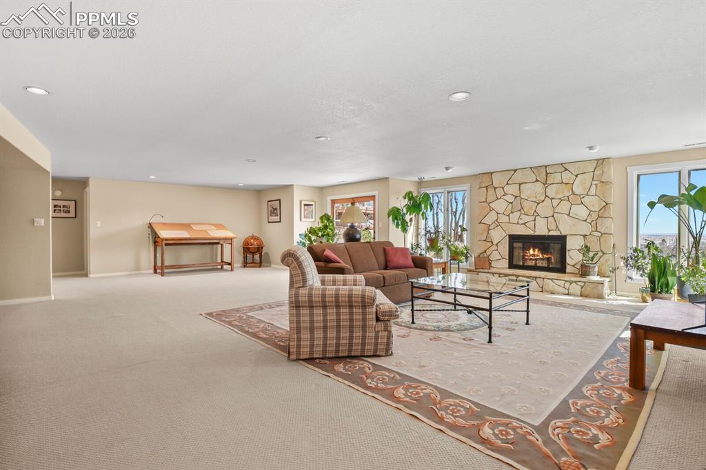 Second larger Family Room in the Lower Level.  French doors to the outside.  Fireplace and stone surround. Lots of windows, lots of canned lights and carpet .