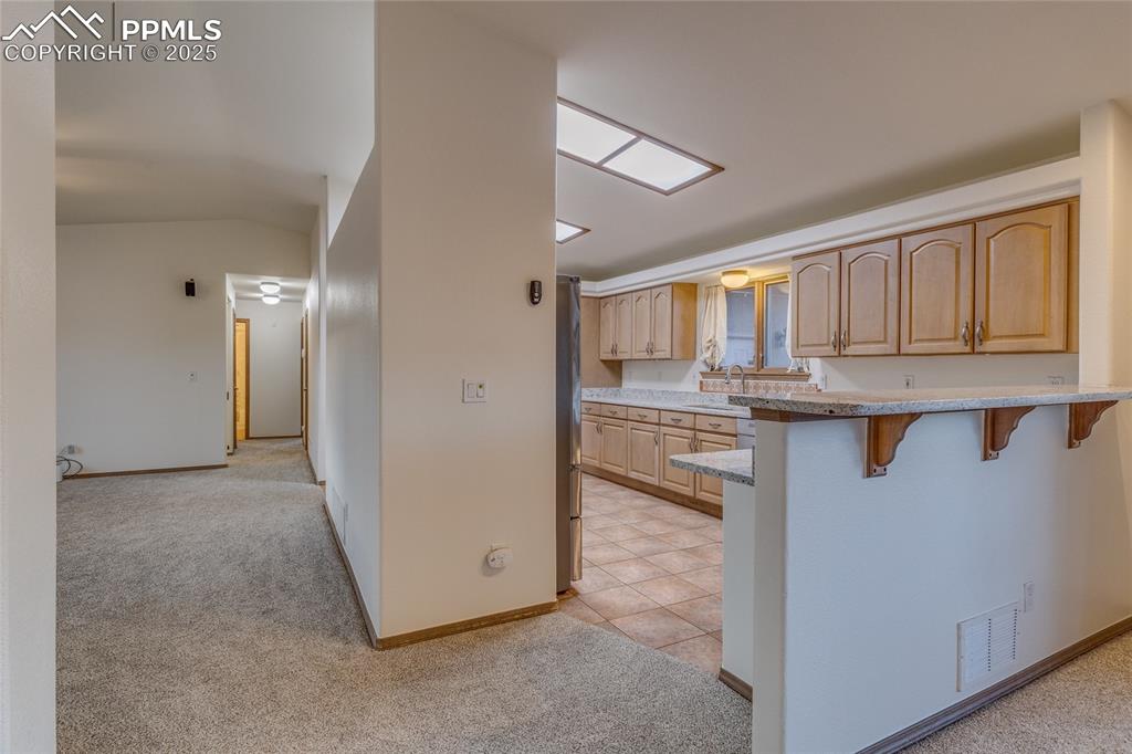 Kitchen with breakfast bar/new granite countertops to the right and living room on the left
