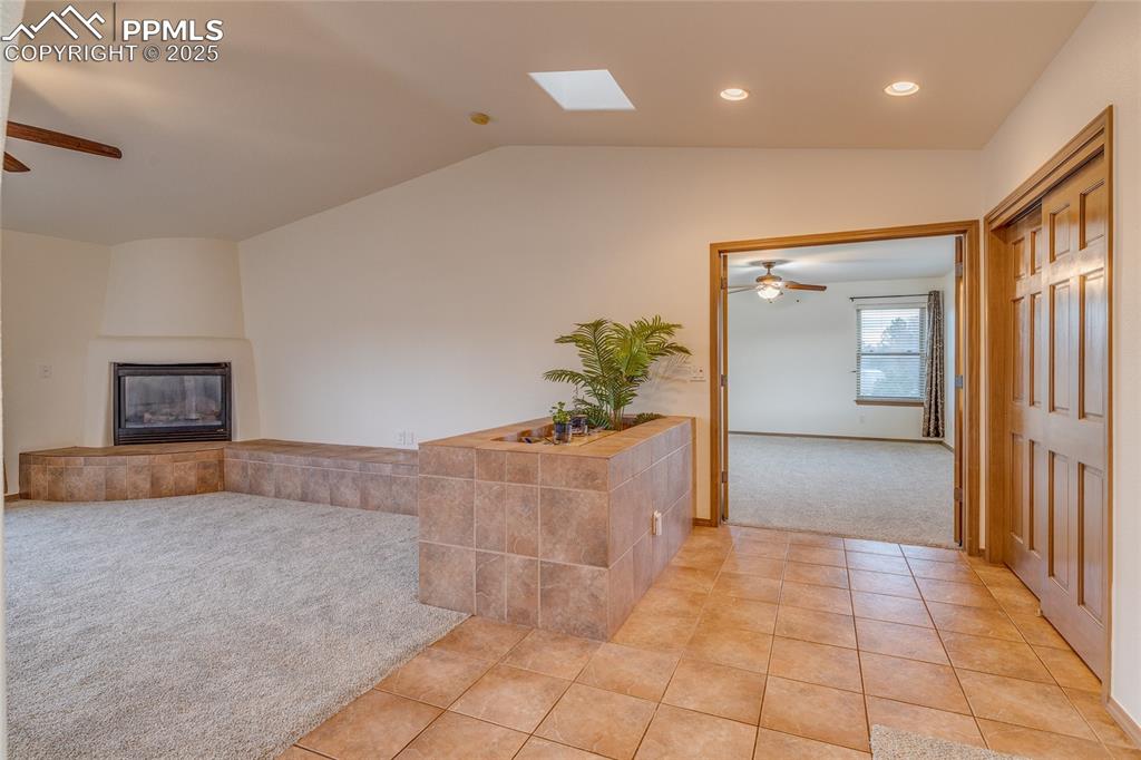From dining room looking toward primary bedroom entry and family room with gas fireplace to the left