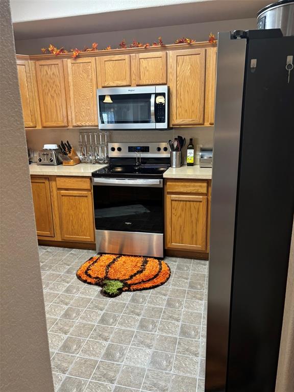 Kitchen with stainless steel appliances and light countertops