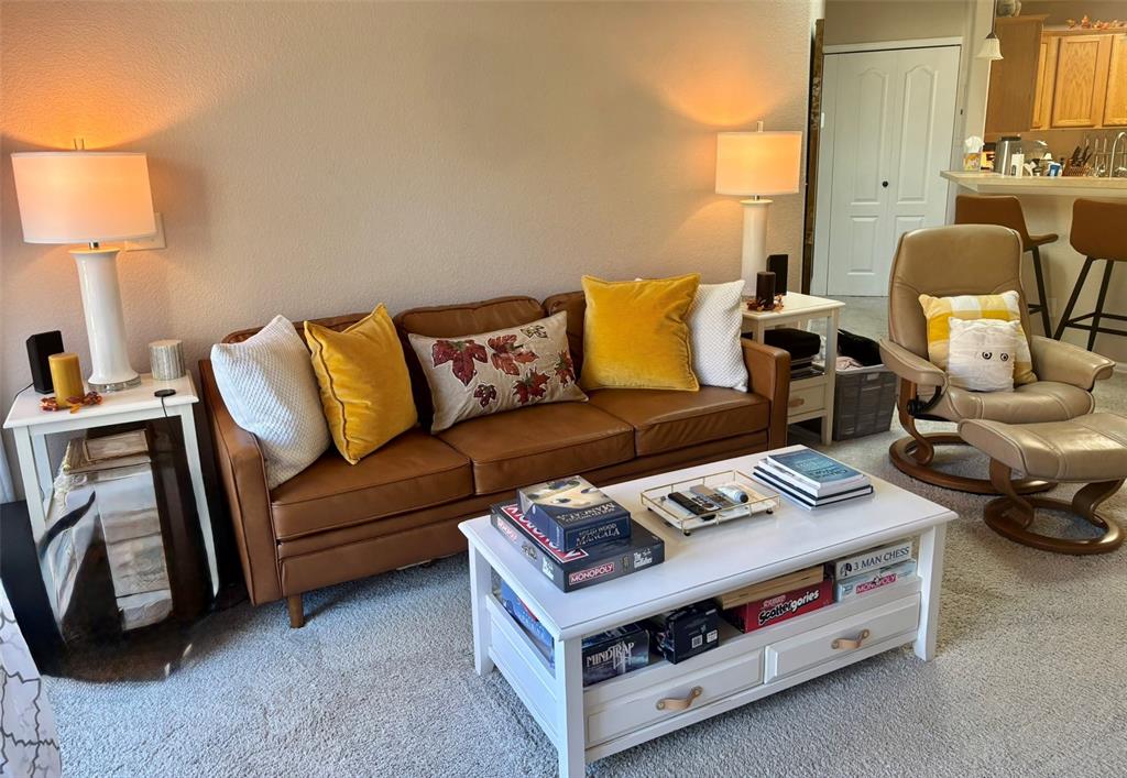 Living room featuring light carpet and a textured wall