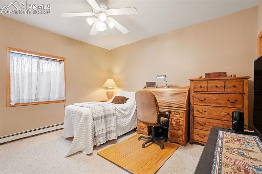Bedroom with ceiling fan and baseboard heating plus direct access to the bathroom