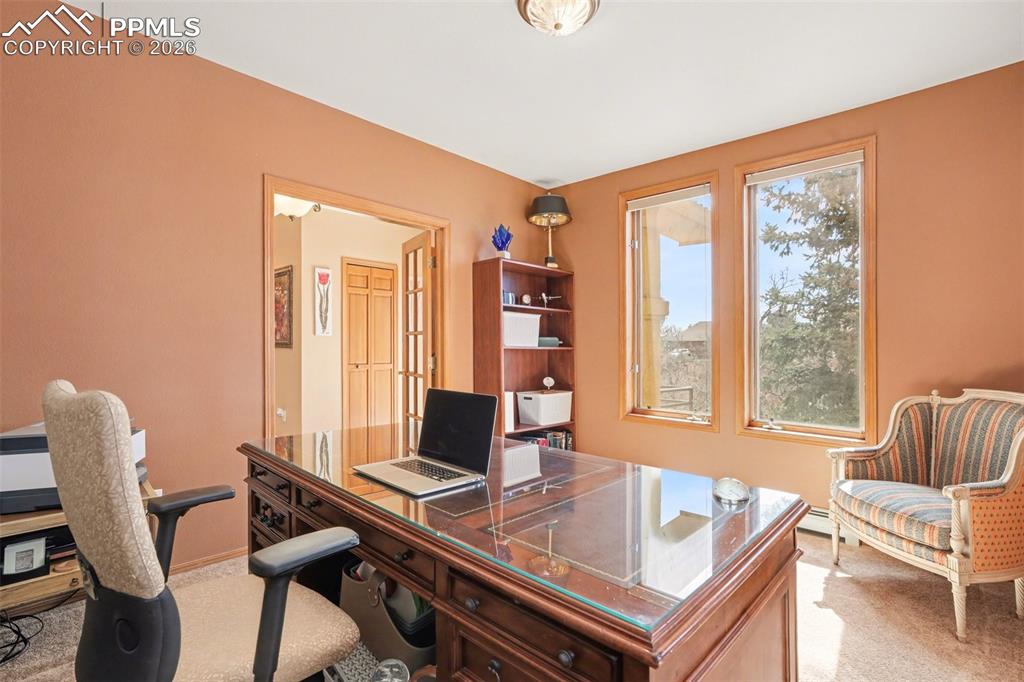 Office space with light colored carpet and baseboards