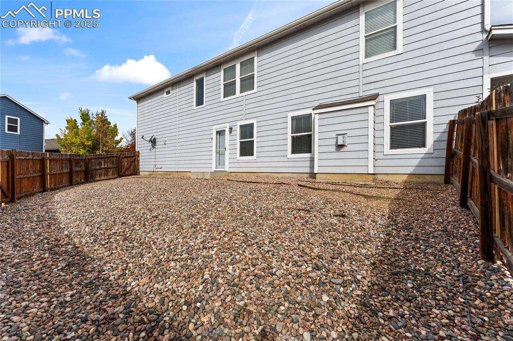 Rear view of house with a fenced backyard